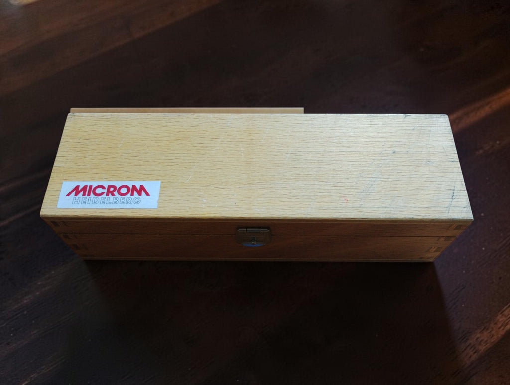 Closed wooden storage case with MICROM Heidelberg label and metal latch.
