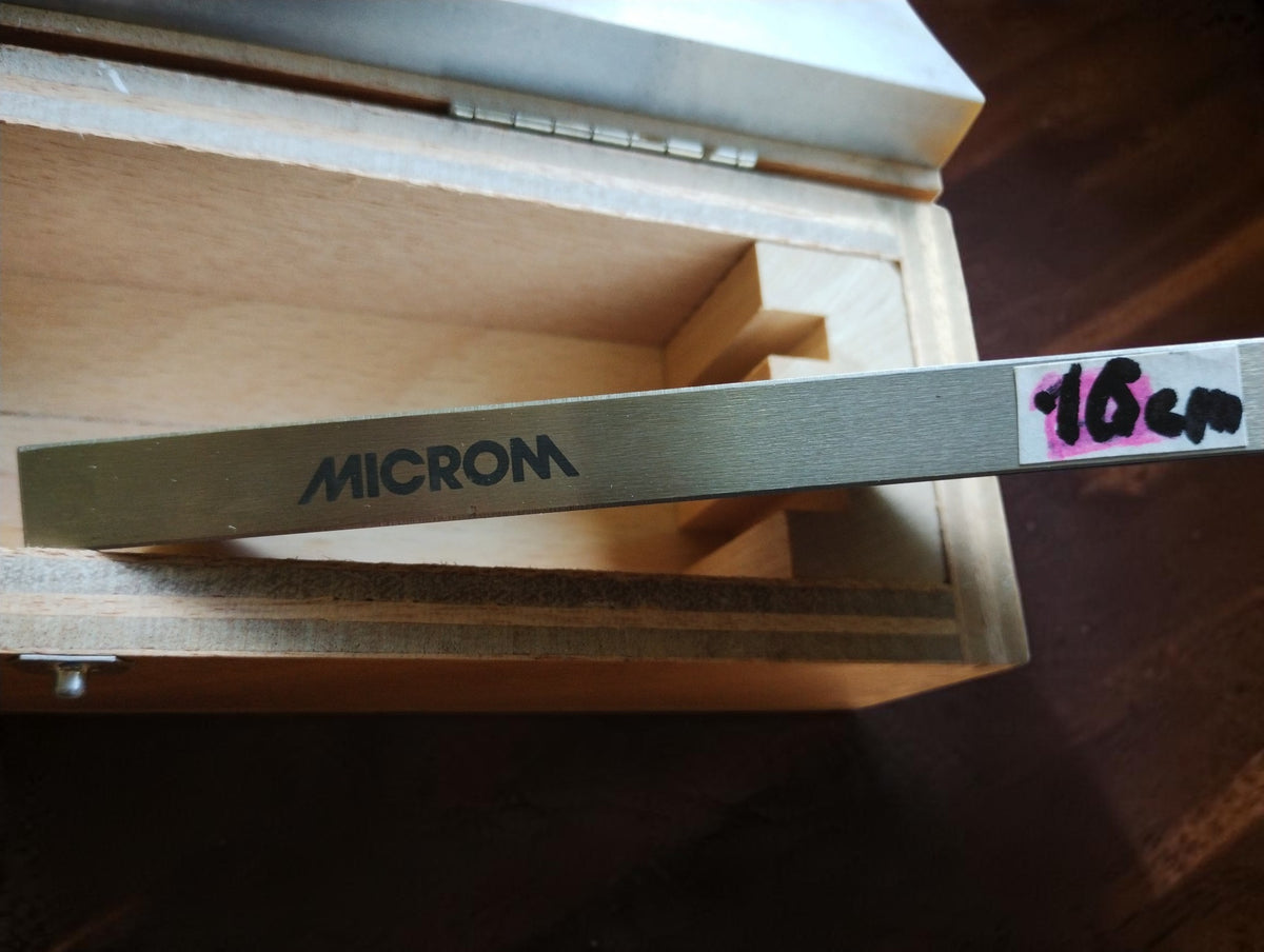 Close-up of the MICROM marking and handwritten 16 cm label on a vintage precision straightedge.

