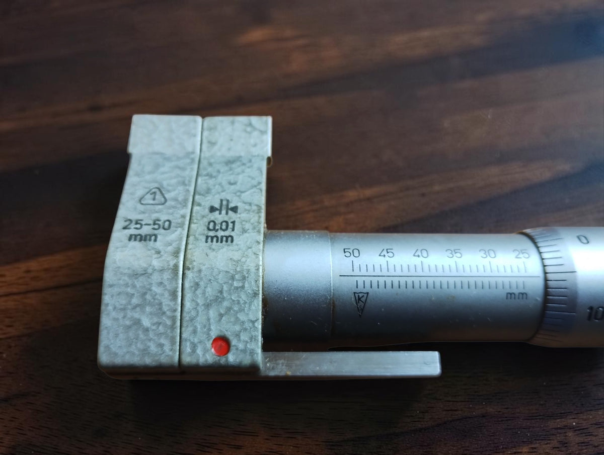 Close-up of DDR inside micrometer showing 25–50 mm measuring range and 0.01 mm scale markings
