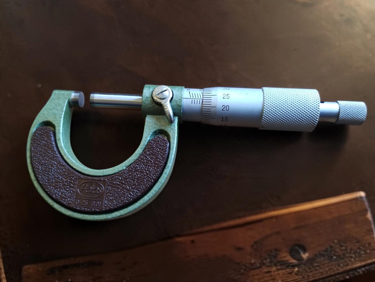 NOS Helios outside micrometer with mint-green frame, brown textured grips and graduated measuring thimble.
