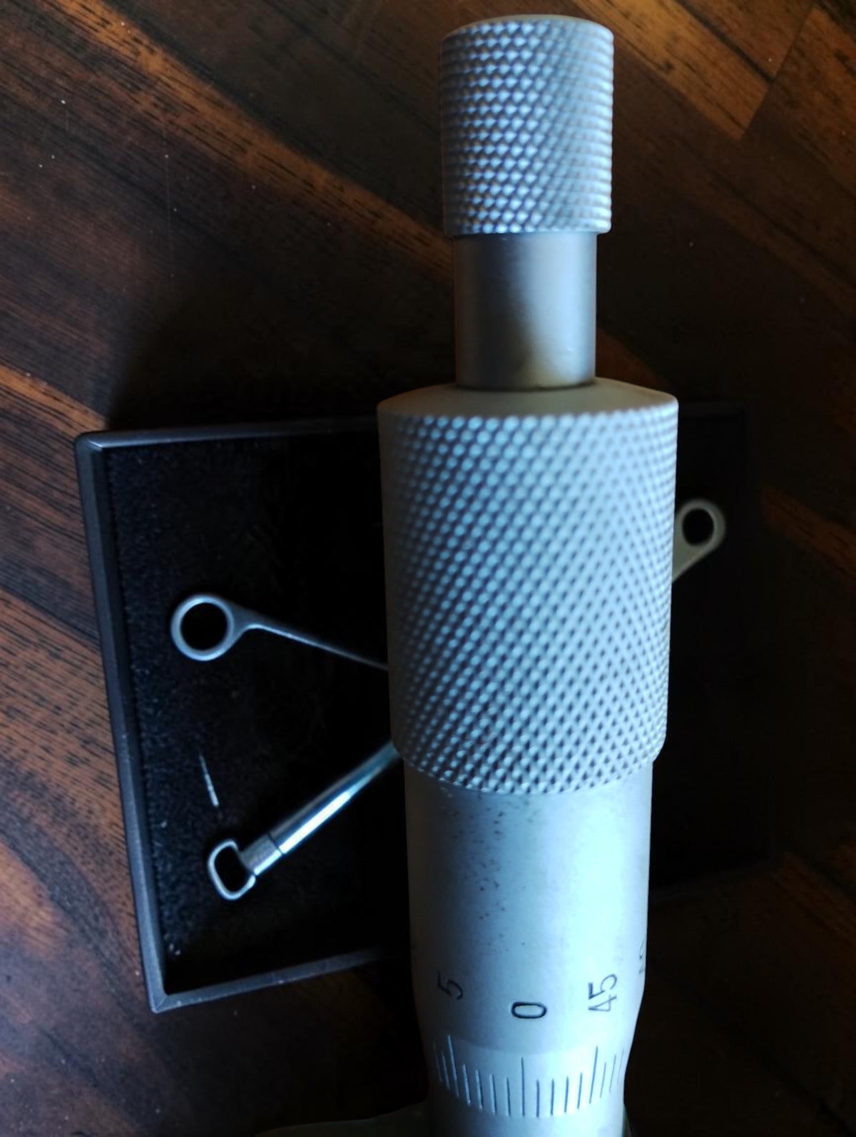 Close-up of the NSK micrometer's knurled thimble, ratchet knob and engraved scale.
