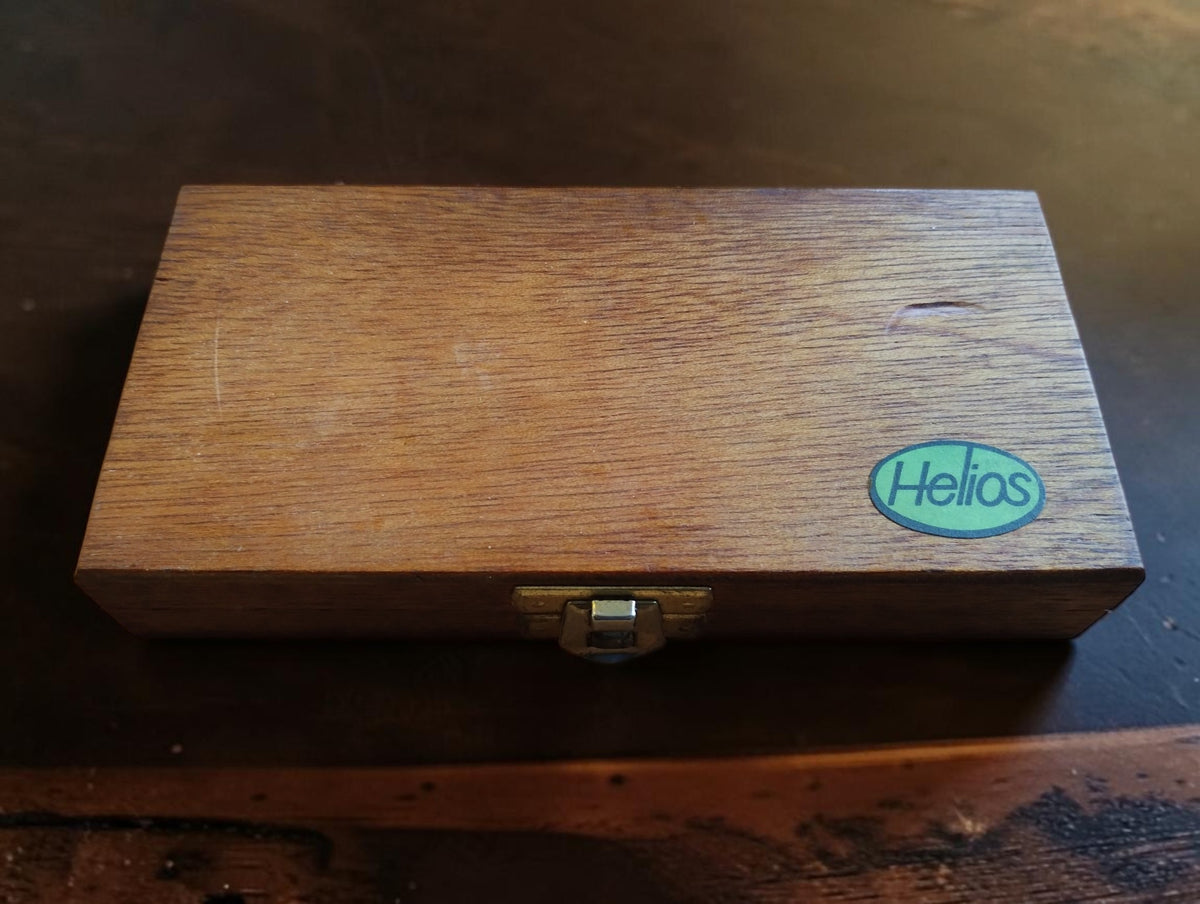 Closed wooden storage case with Helios label and metal clasp for the NOS outside micrometer.
