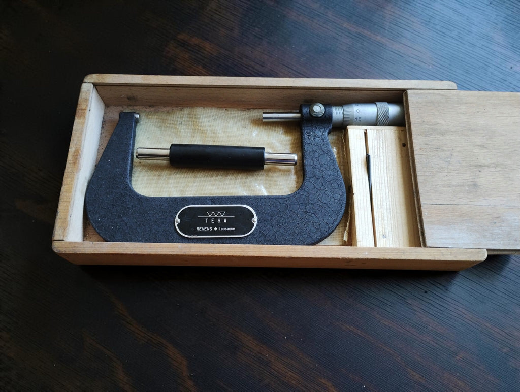 Vintage TESA 75–100 mm outside micrometer in an open wooden sliding-lid case with setting standard.
