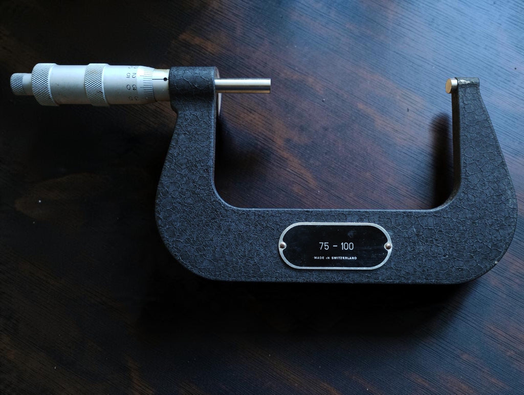Rear view of the TESA outside micrometer showing the 75–100 range plate and Made in Switzerland marking.
