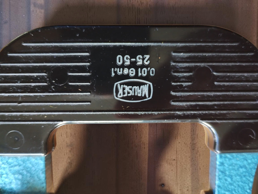 Close-up of the Mauser logo and 0.01 Gen.1 and 25–50 markings on the micrometer's black ribbed grip.
