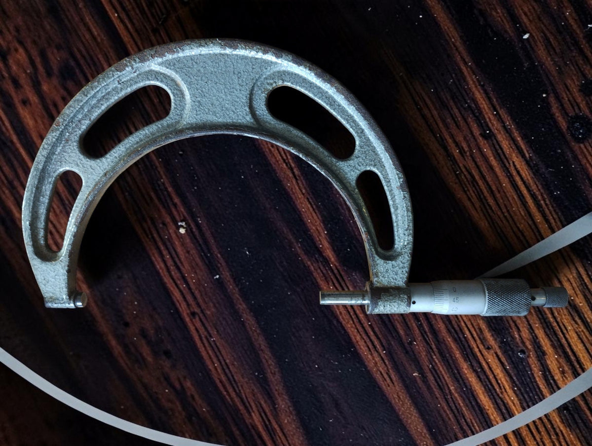 Reverse side of the vintage NSK outside micrometer, showing the open metal frame and graduated thimble.
