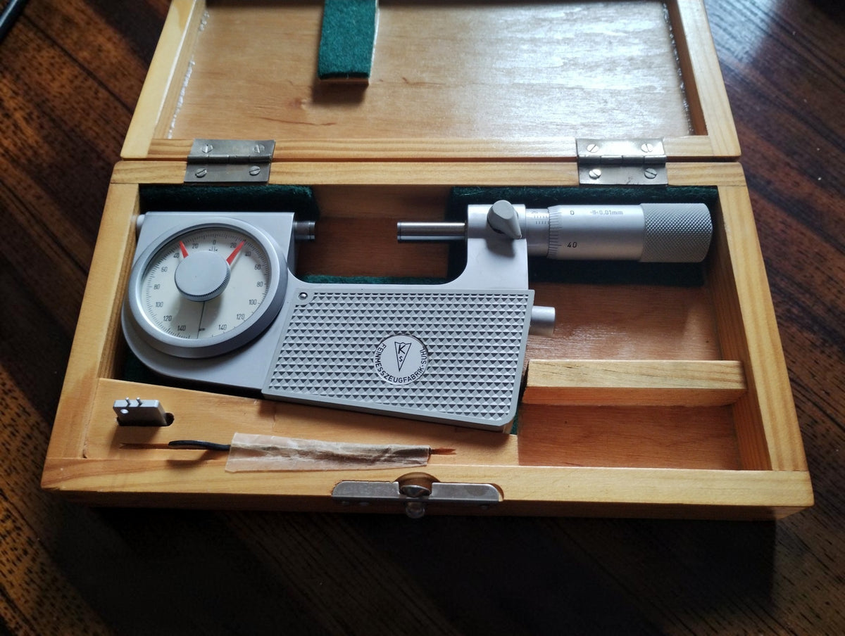 Feinmesszeugfabrik Suhl 25–50 mm indicating micrometer in an open wooden storage case.
