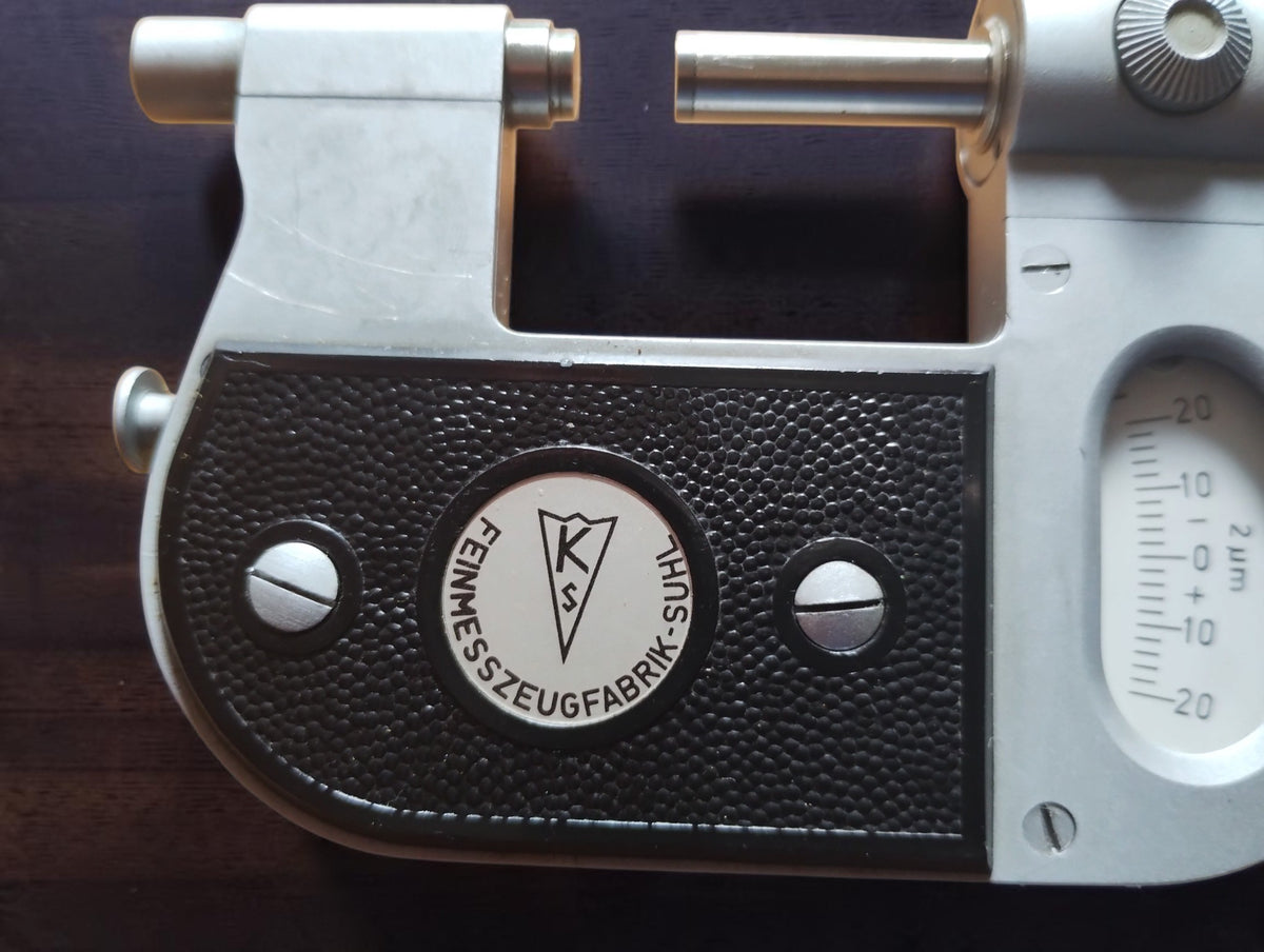 Close-up of the triangular K S logo and Feinmesszeugfabrik Suhl maker's badge on the black grip panel.
