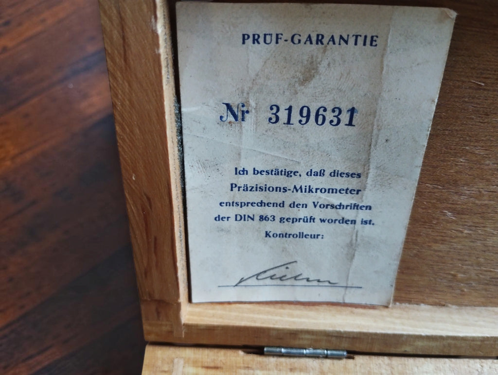 Historic Prüf-Garantie inspection certificate numbered 319631 with a controller's signature inside the wooden case
