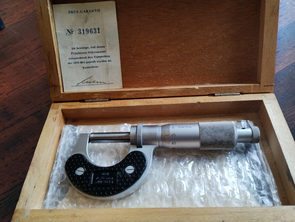 MATRA outside micrometer inside its wooden case with the Prüf-Garantie inspection certificate in the lid
