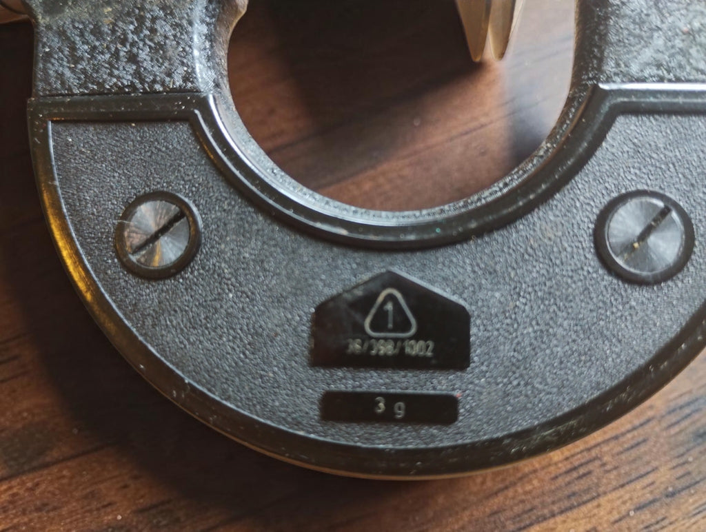 Triangle marking with the number 1 and additional identification markings on the Massi micrometer frame.
