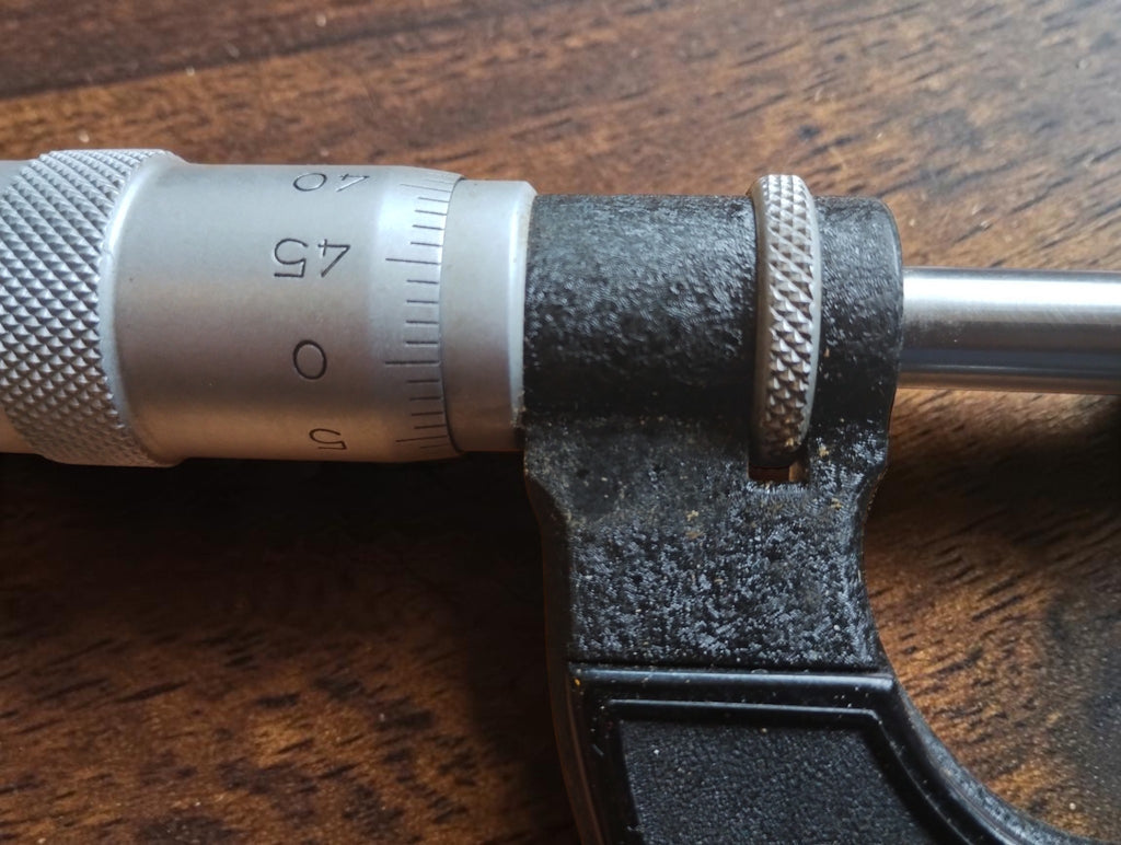 Close-up of the Massi micrometer's graduated thimble, knurled adjustment ring, and spindle.
