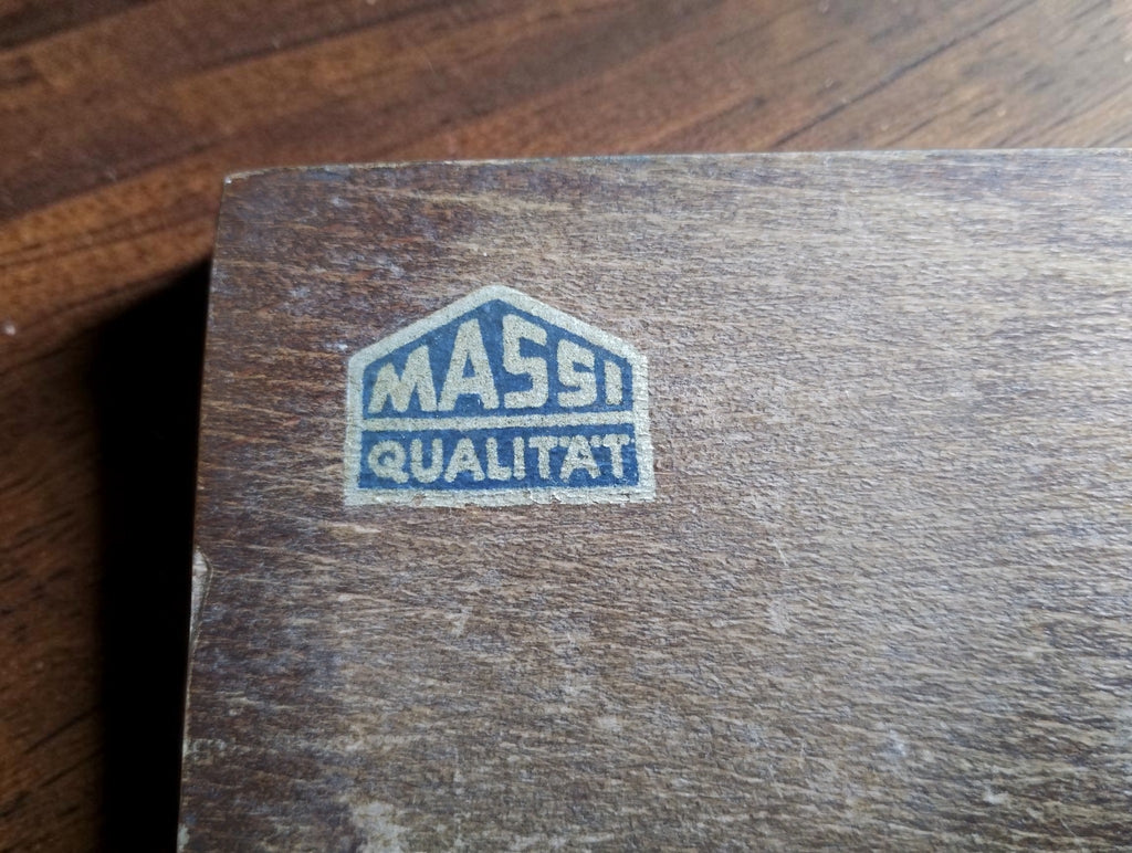 Blue and silver Massi Qualität label on the wooden micrometer case.
