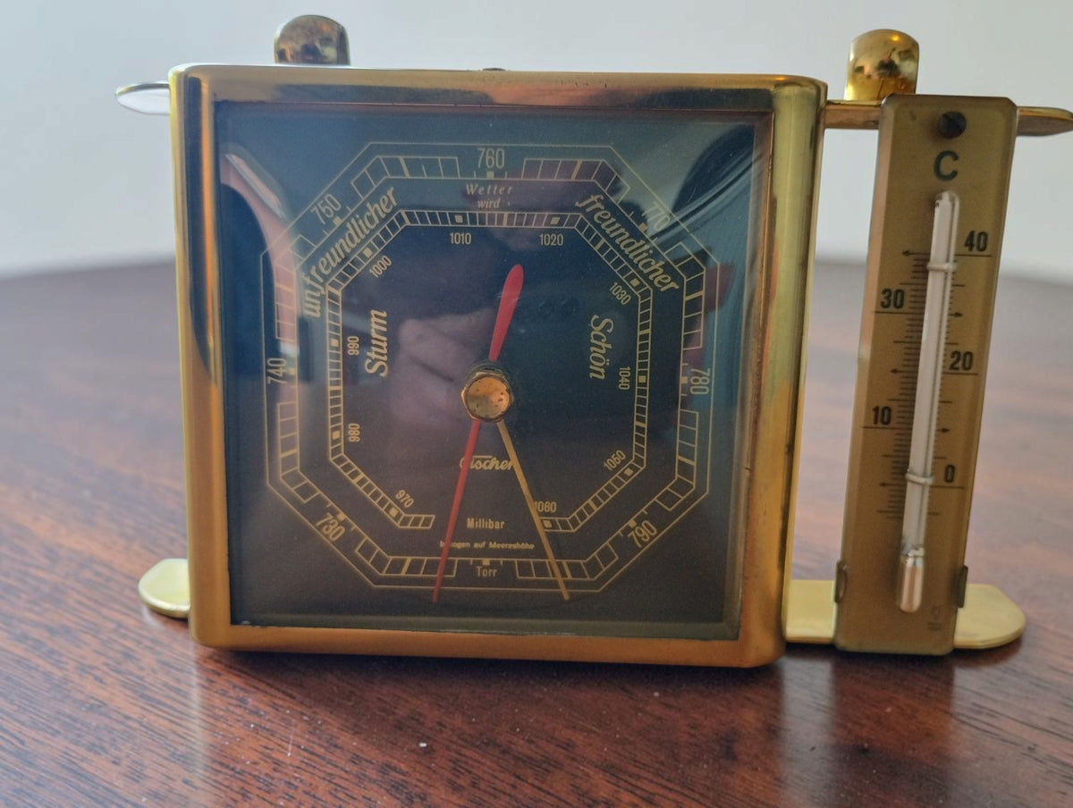 Vintage Fischer tabletop barometer with a gold-tone frame, octagonal dial and Celsius thermometer on the right.
