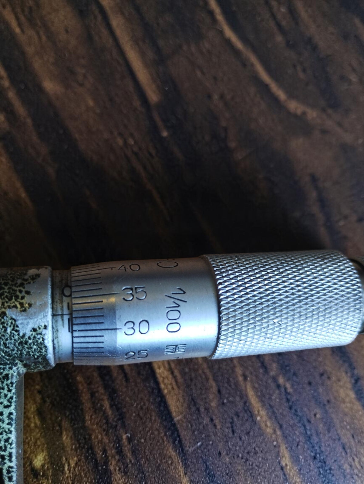 Close-up of the Hommelwerke micrometer thimble showing the 1/100 mm graduation marking and knurled grip.
