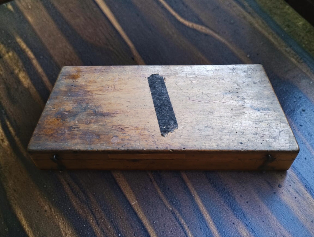 Closed wooden storage box for the Hommelwerke outside micrometer, showing surface wear and an old label remnant.
