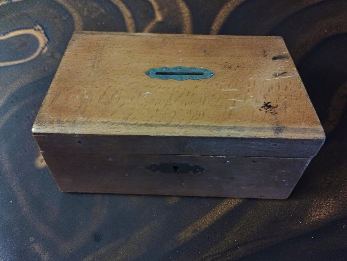 Closed wooden case for the antique watchmaker’s lantern runner set, showing the metal-lined lid slot and signs of wear.
