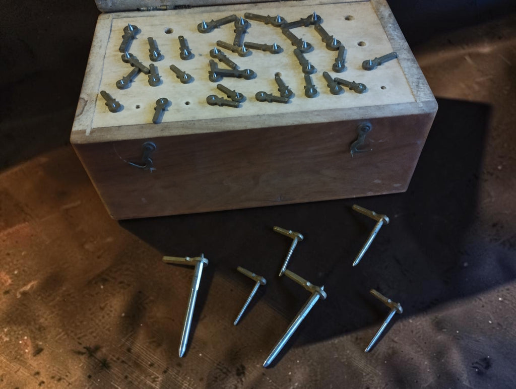 Antique watchmaker's topping tool cutter set in a wooden case, with six loose guide pins displayed in front.
