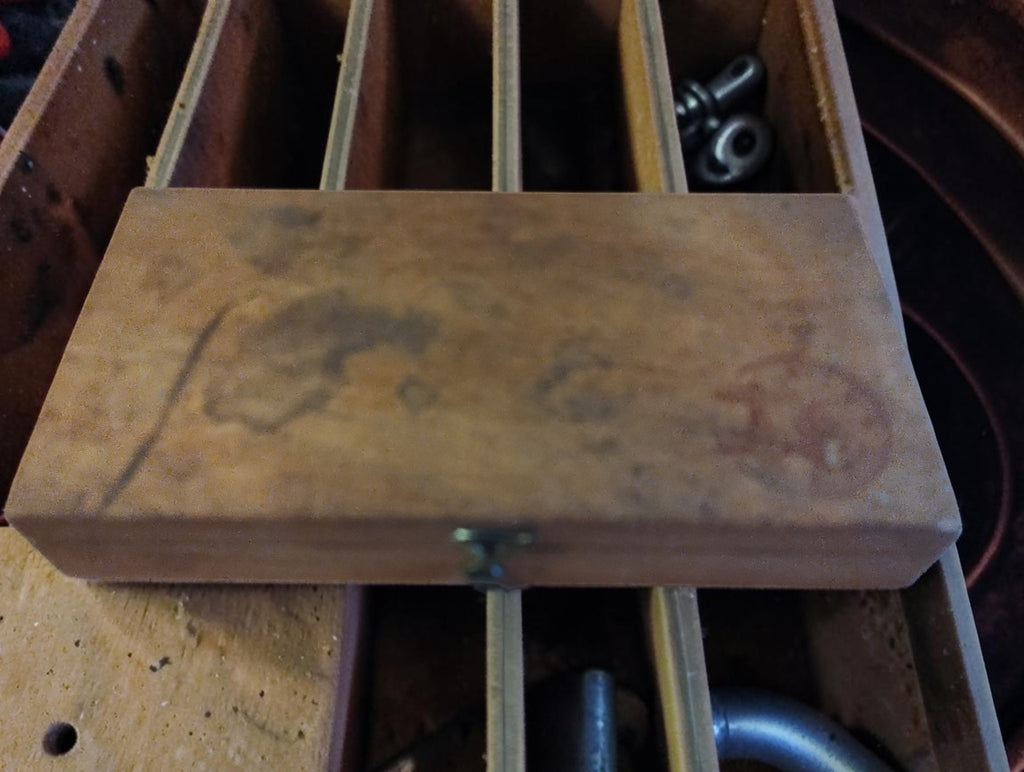 Closed wooden Ludwig & Fries assortment box with a faded circular stamp, front clasp, and visible wear.
