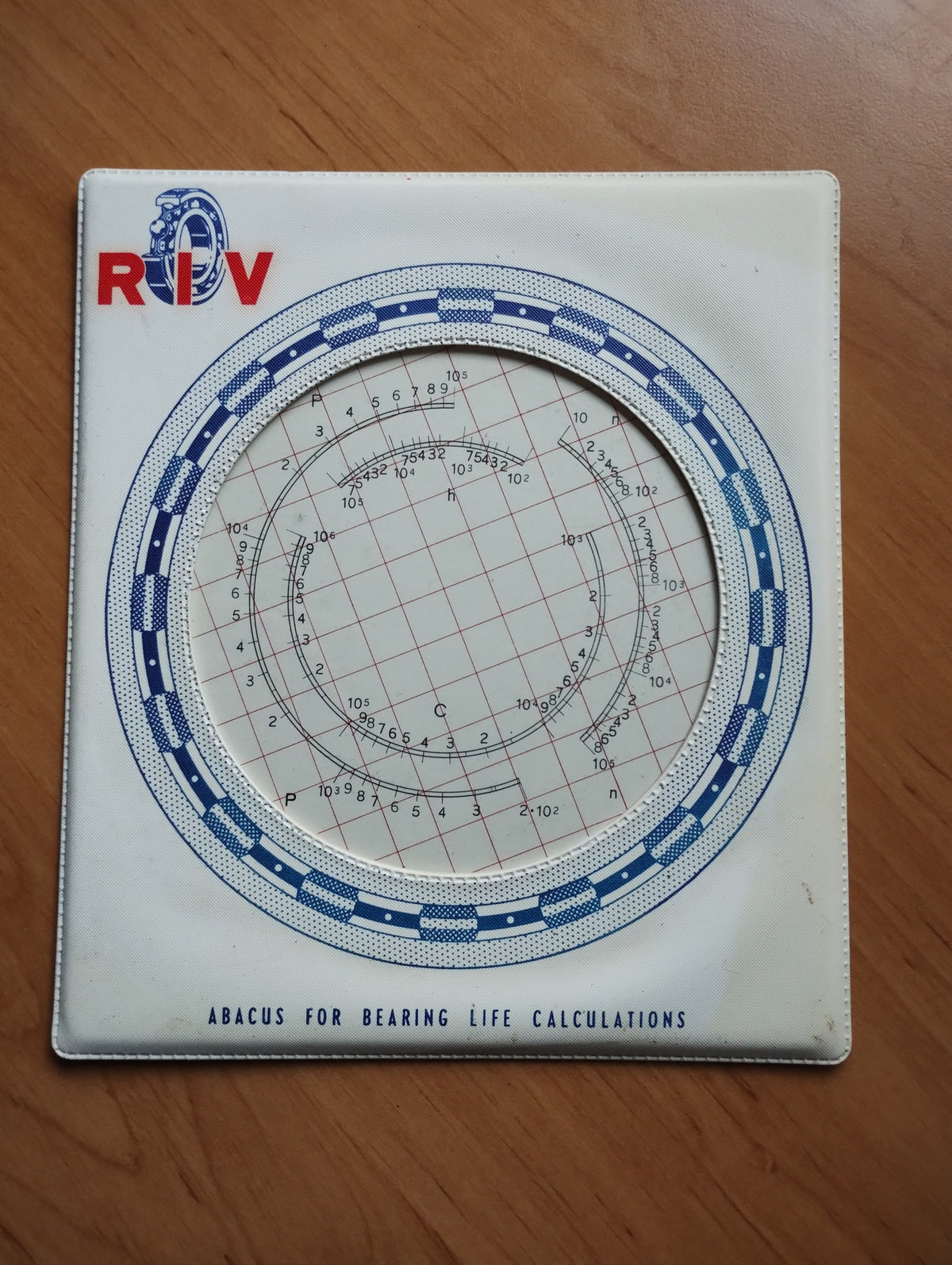 RIV vintage bearing life calculator with circular scales, red and blue logo, and blue-and-white border.

