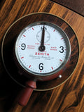 Antique Zenith Le Locle telephone timer with white dial, red markings, metal bezel and reddish-brown operating handle, angled view.

