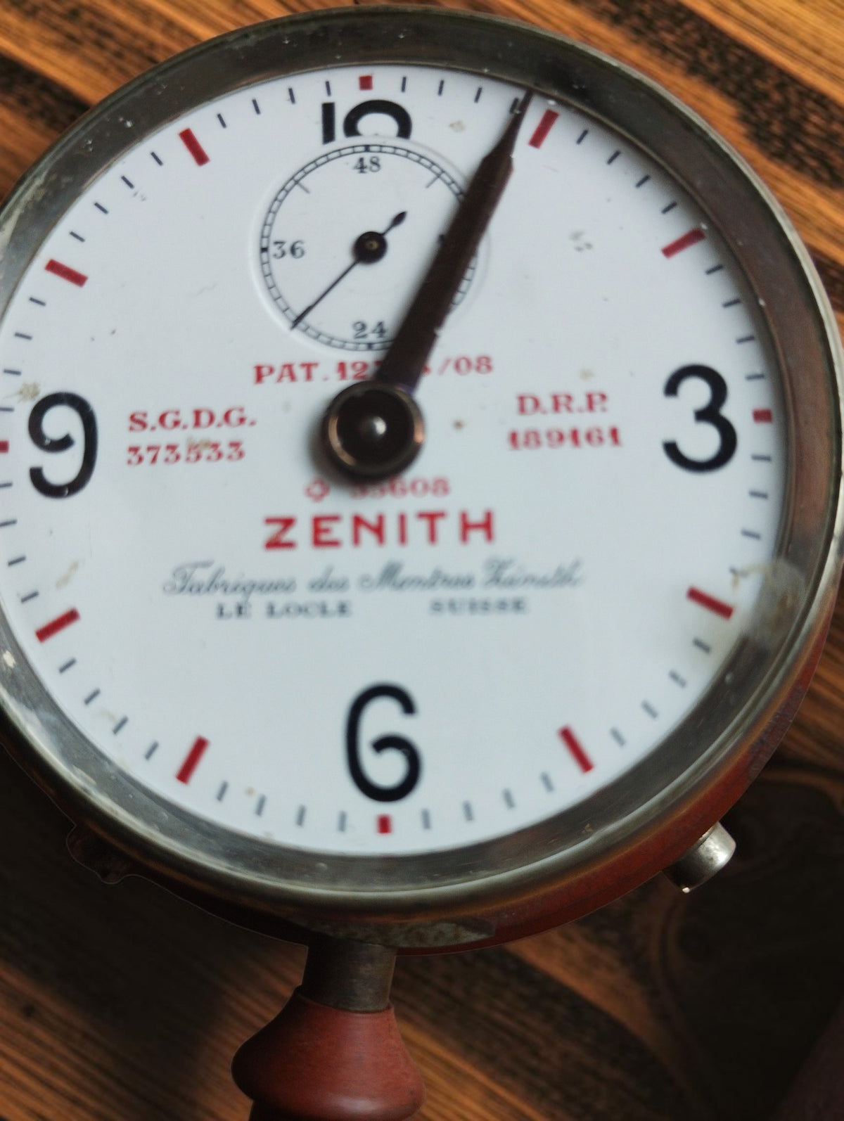 Close-up of the Zenith telephone timer dial with red ZENITH lettering, Swiss maker inscription, patent markings and small counter.
