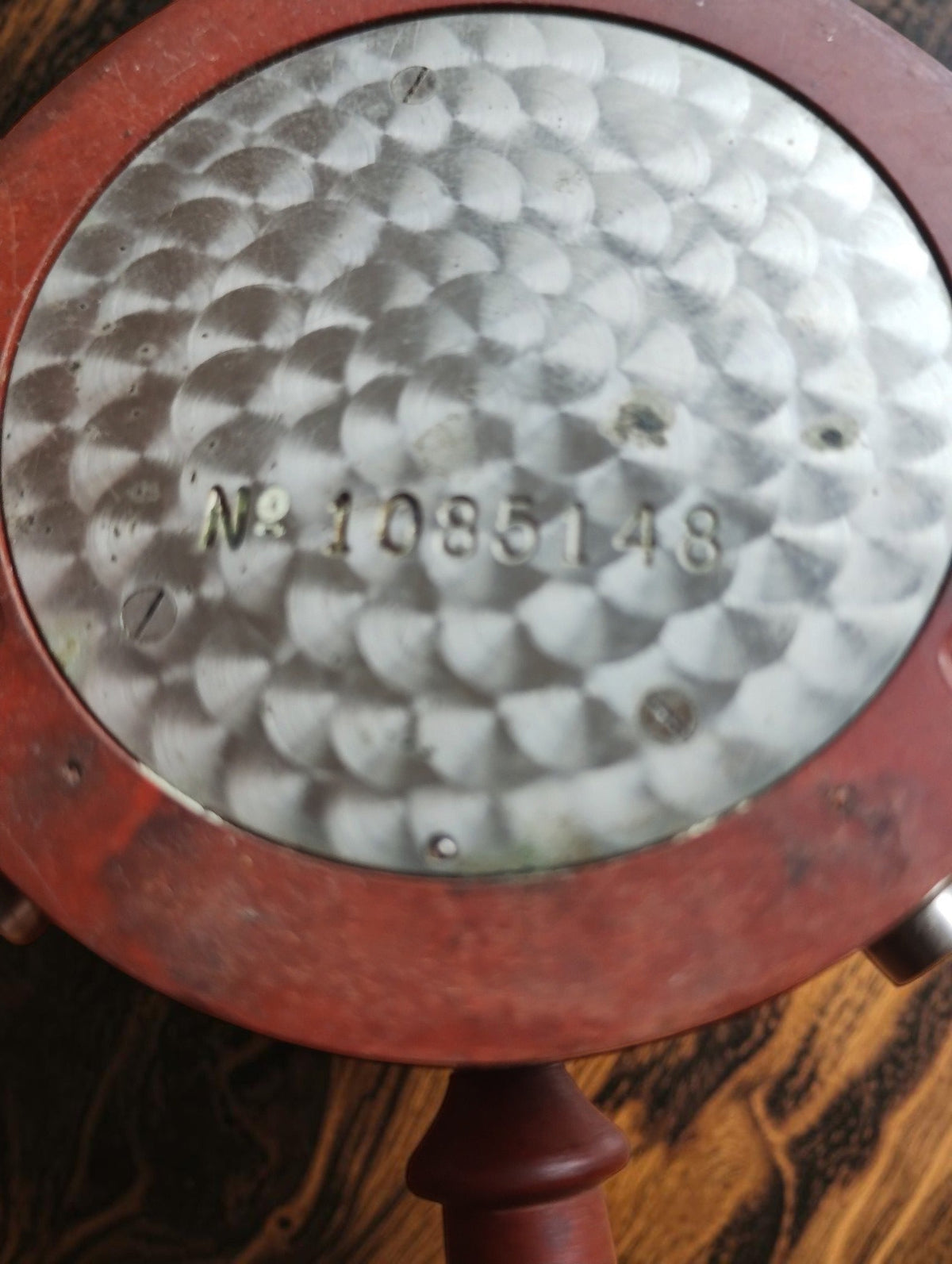 Rear view of the Zenith telephone timer showing the engraved serial number, circular perlage decoration and wear on the red case.
