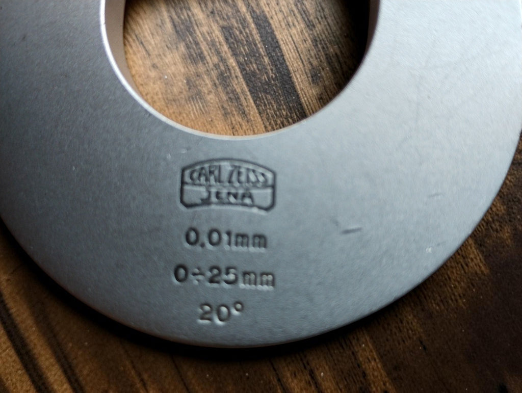 Carl Zeiss Jena micrometer markings showing the 0–25 mm range, 0.01 mm graduations, and 20° inscription.
