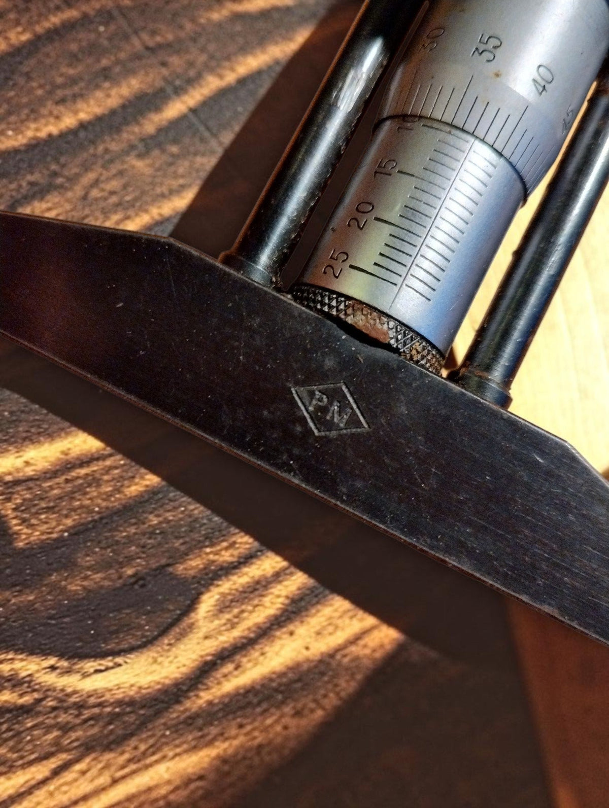 Detail of the diamond-shaped maker's mark on the depth micrometer measuring bridge
