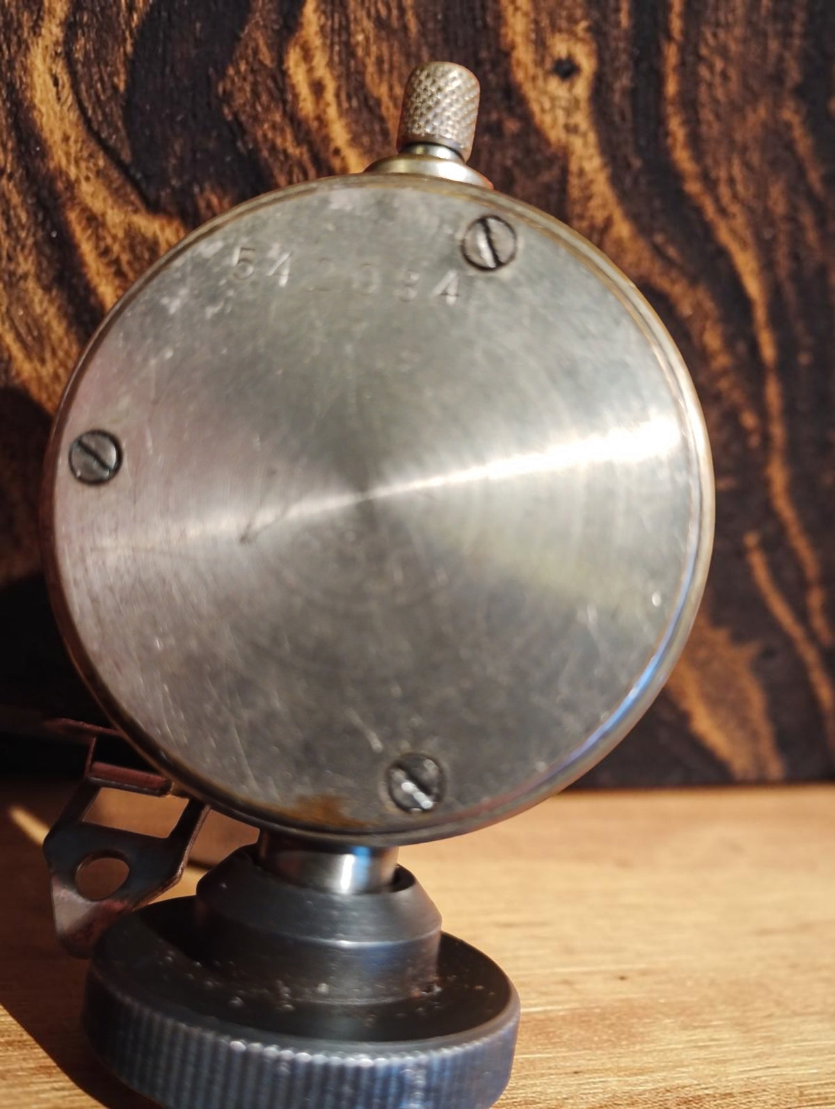 Rear view of the dial indicator showing the metal housing and three slotted screws
