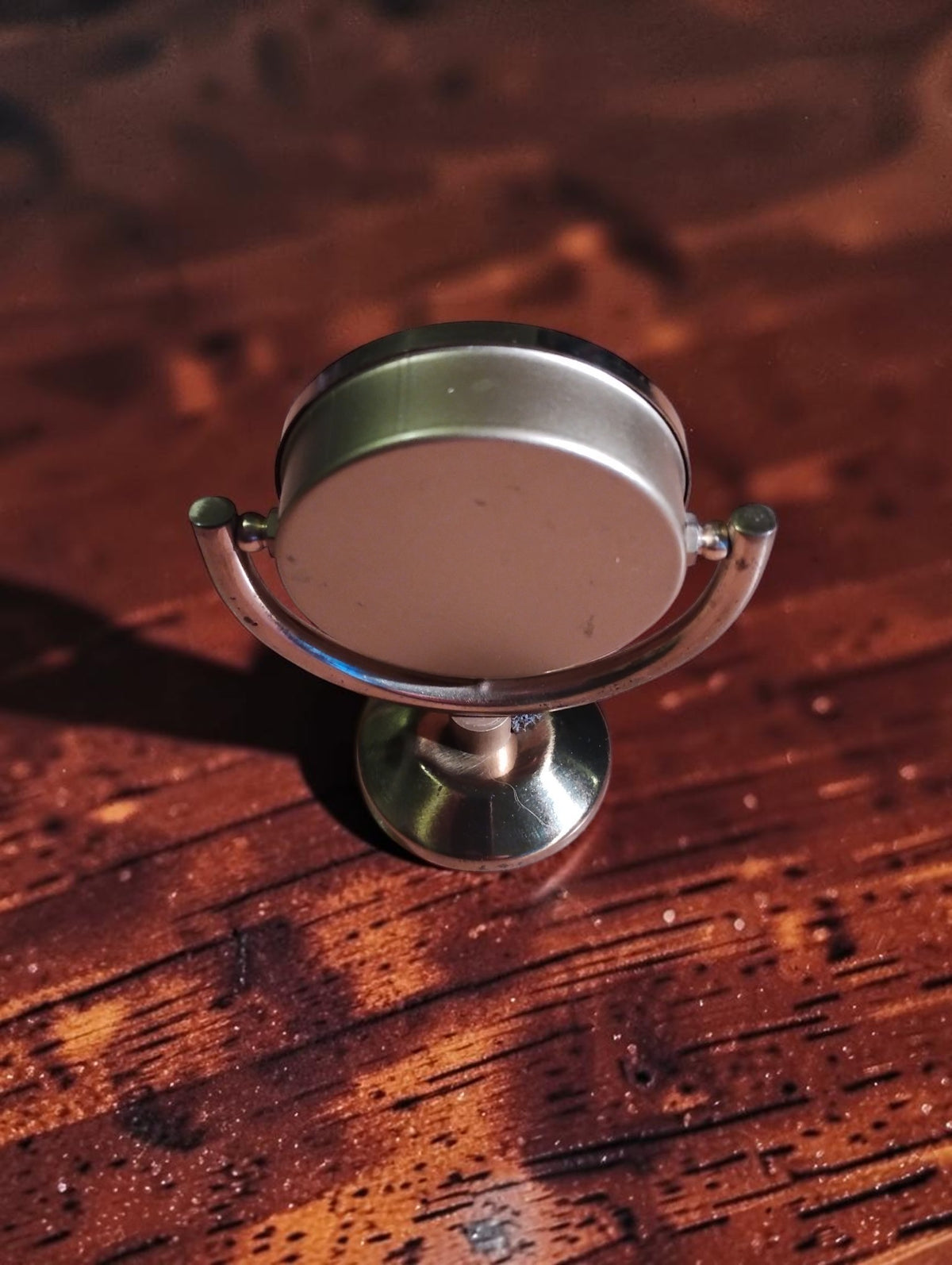 Rear view of the vintage brass desk thermometer showing the plain back, curved cradle and pedestal base.
