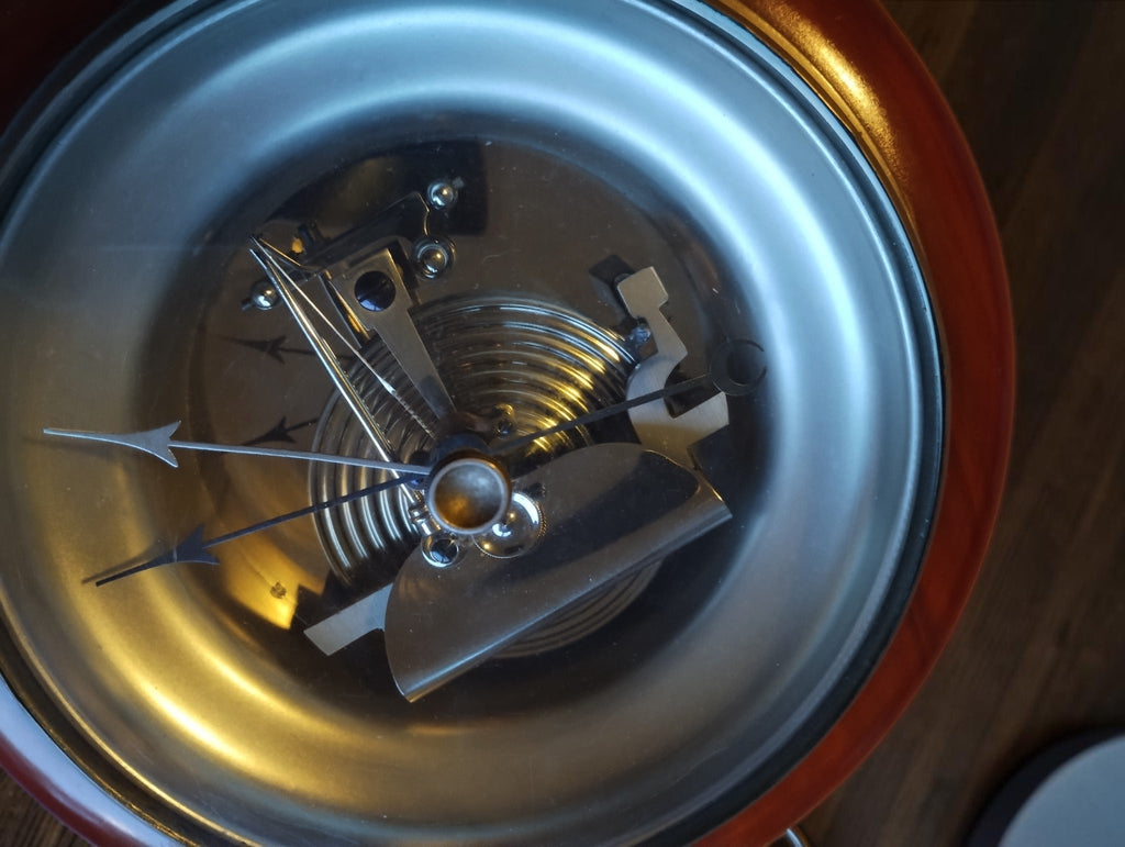 Angled view of the exposed barometer mechanism, showing the capsule, linkages and two pointers.
