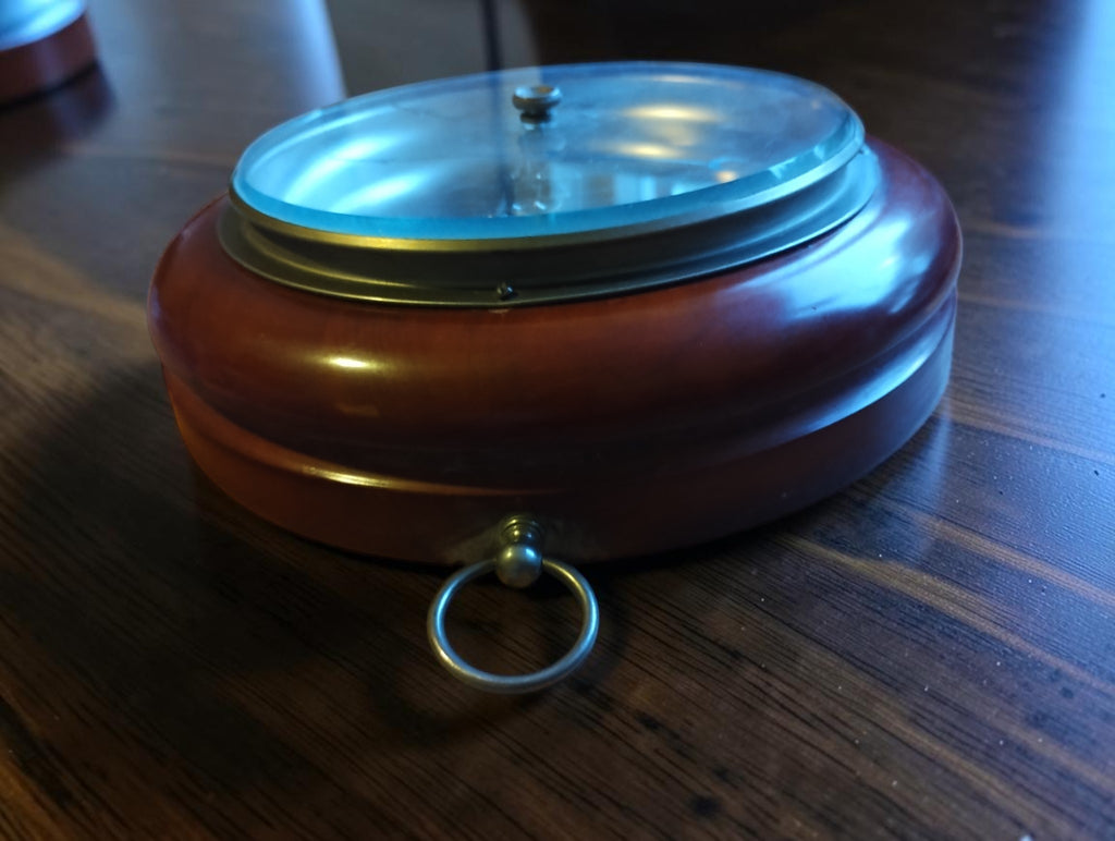 Side view of the wooden barometer case, showing the raised glass cover and metal hanging ring.
