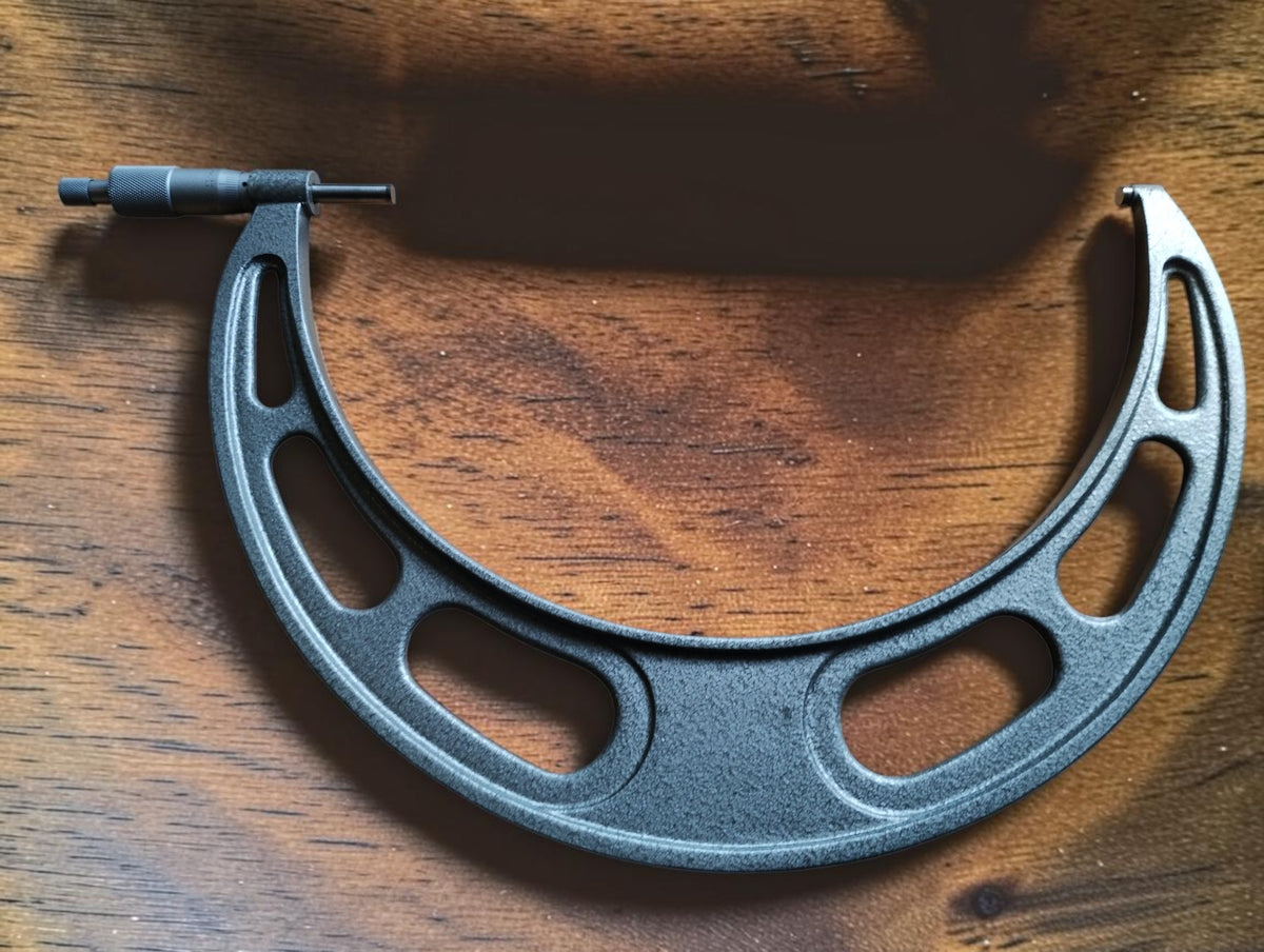 Reverse side of the NSK outside micrometer, showing the large openwork frame and gray hammertone finish.

