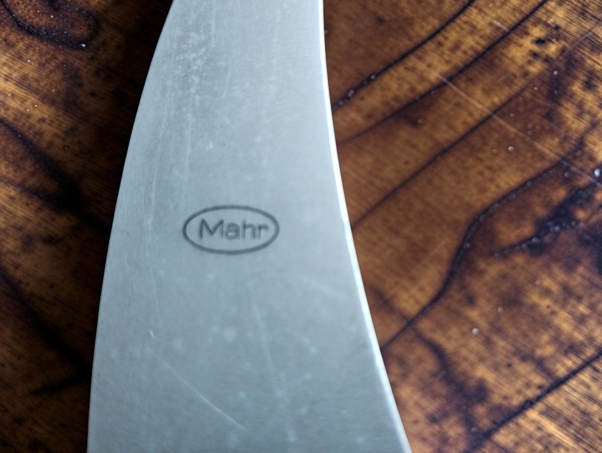 Close-up of the oval Mahr logo on the metal frame of the outside micrometer.
