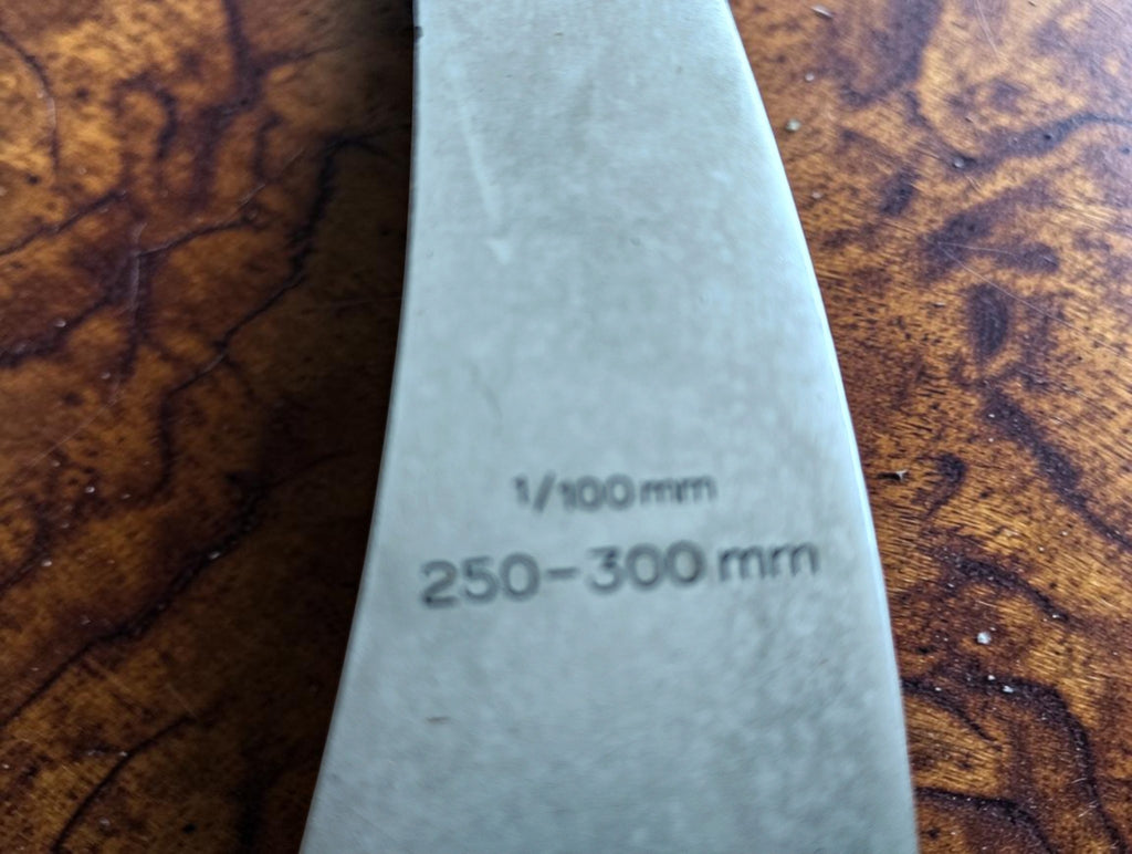 Close-up of the 250–300 mm measuring range and 1/100 mm graduation markings on the Mahr micrometer.
