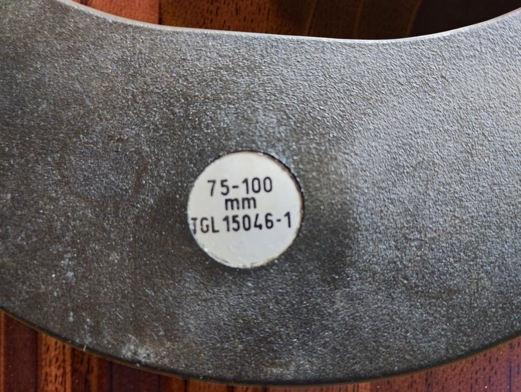 Close-up of the micrometer frame label marked 75–100 mm and TGL 15046-1.
