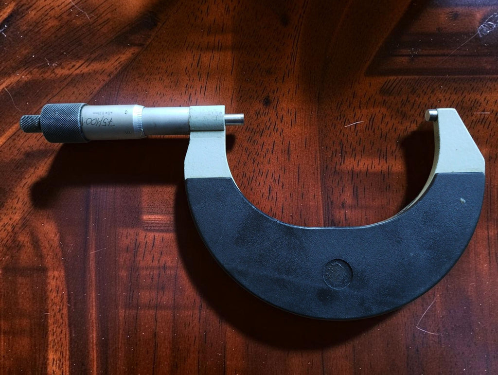 Full view of the 75–100 mm outside micrometer showing its curved frame, spindle, anvil and knurled adjustment knob.
