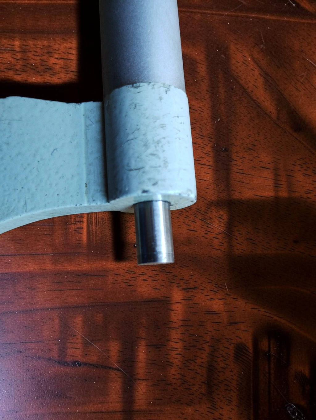 Close-up of the micrometer spindle and surrounding metal housing, showing surface wear and paint loss.
