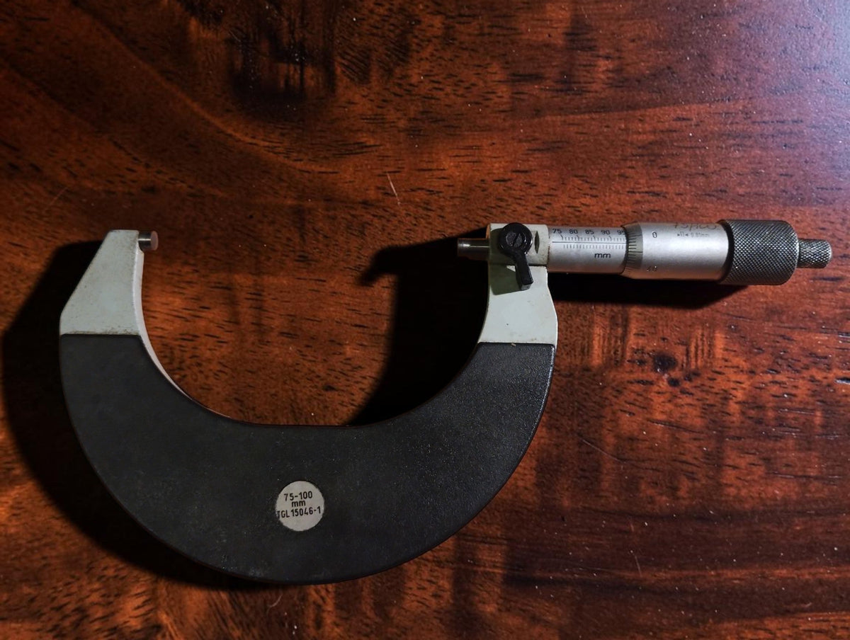 Opposite-side view of the 75–100 mm outside micrometer showing the TGL label, scale and locking lever.
