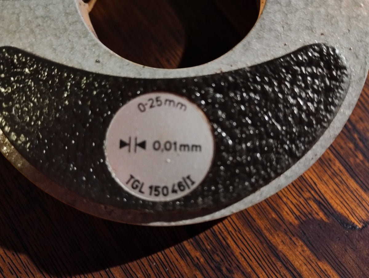 Micrometer label showing the 0–25 mm range, 0.01 mm graduations and TGL 15046/1 standard
