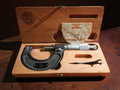 Roch Paris 25–50 mm outside micrometer in its original wooden case with adjustment wrench and French guarantee document.
