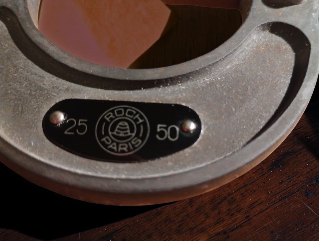 Close-up of the Roch Paris maker's plate and 25–50 mm range markings on the micrometer frame.
