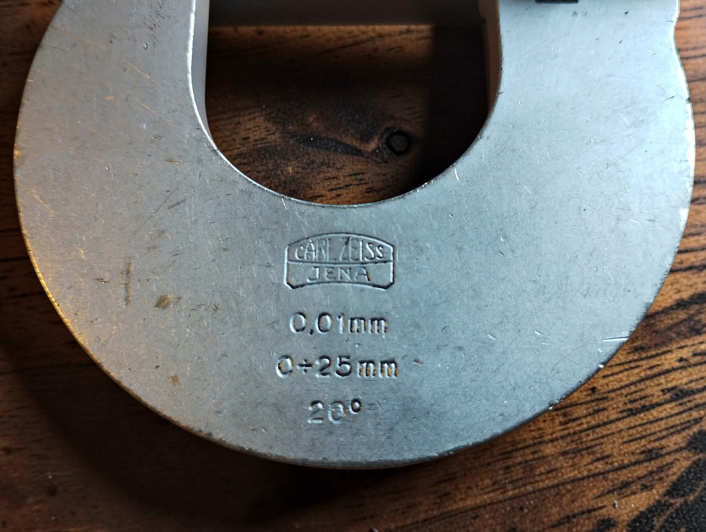 Close-up of the Carl Zeiss Jena logo, 0–25 mm range and 0.01 mm graduations marked on the micrometer frame.

