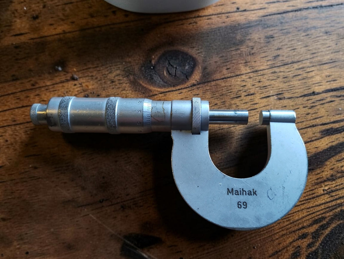 Vintage Carl Zeiss Jena outside micrometer showing the Maihak 69 marking, spindle and thimble on a wooden surface.
