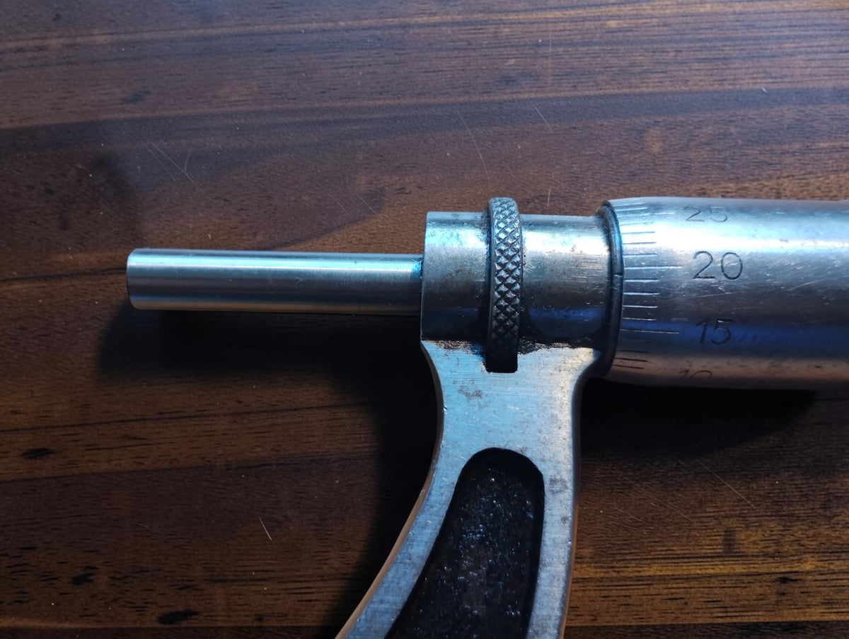 Close-up of the vintage outside micrometer spindle, knurled locking ring and engraved thimble graduations.
