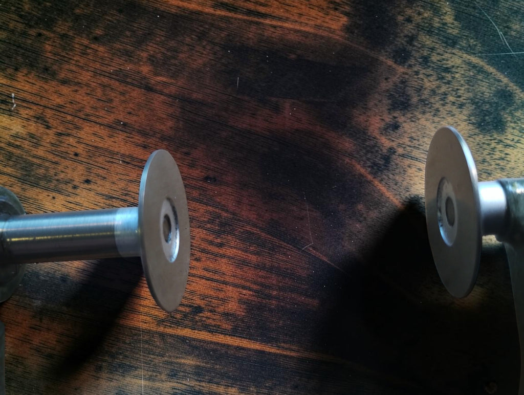 Close-up of the two flat, circular measuring faces of a vintage disc micrometer.
