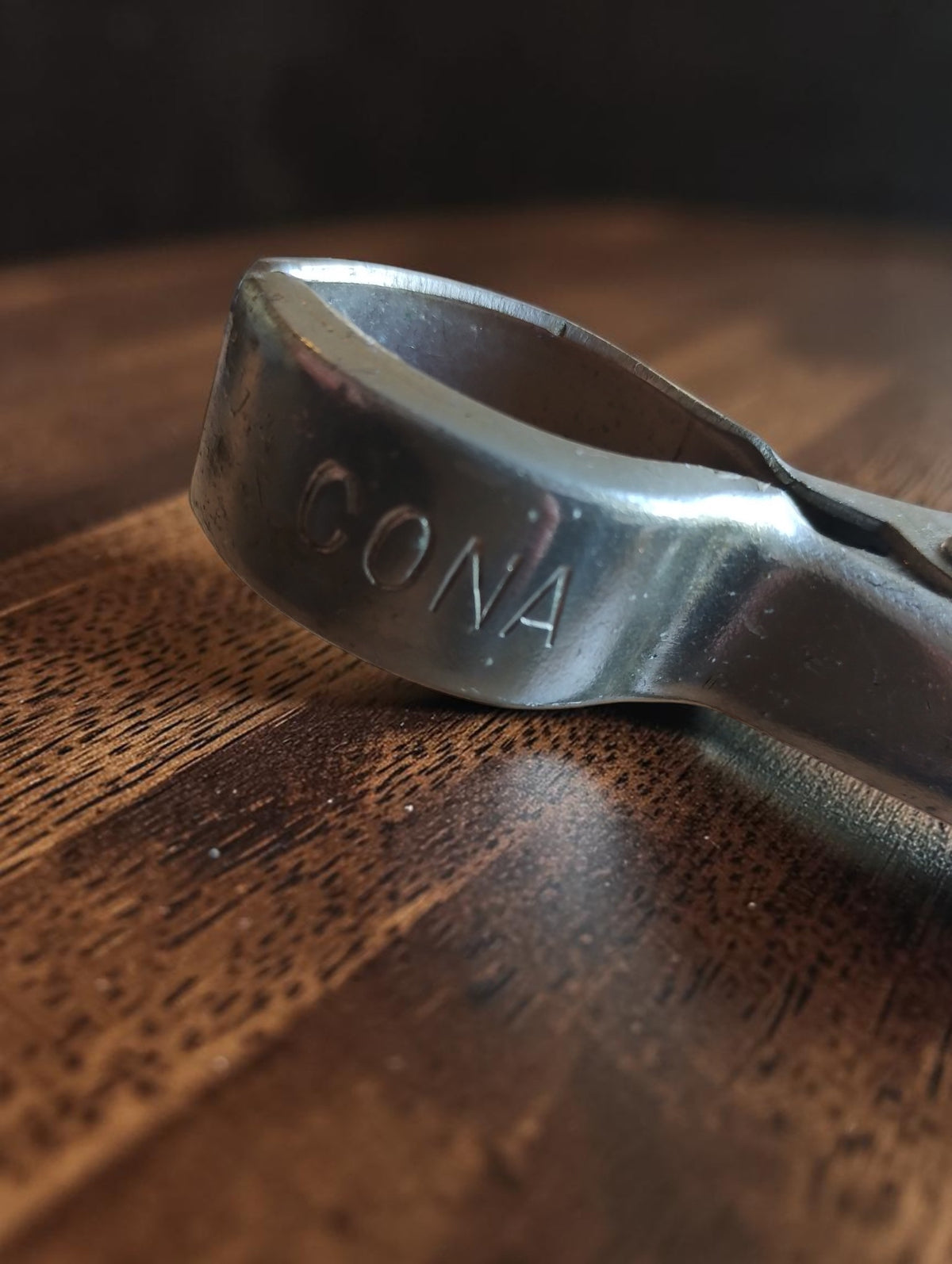 Close-up of the metal spring clip on the arm of a vintage CONA stamp
