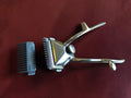 Vintage ERN Solingen manual hair clipper with detached comb attachment on a burgundy background

