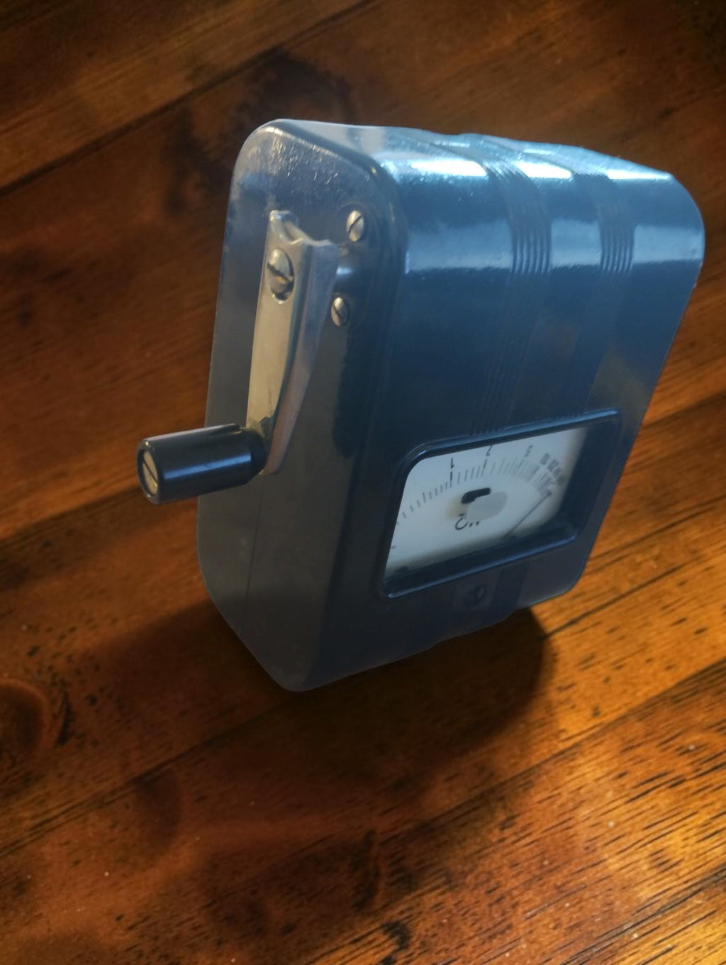 Angled view of the vintage Gossen ISOGNOM insulation tester showing its black housing, analog dial and hand crank.

